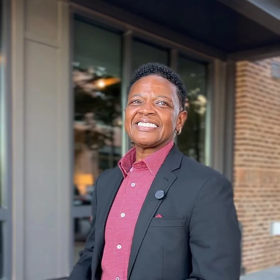 Shelia Brewington, owner of a construction firm, smiling outside a building